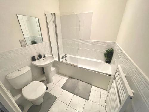 a bathroom with a toilet and a sink and a bath tub at Spacious & Quiet, a perfect base in Bishops Stortford