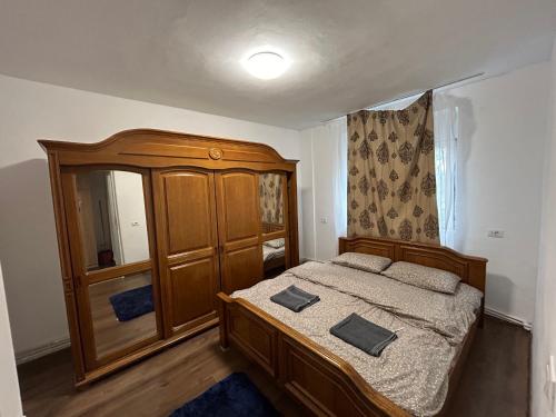 - une chambre avec un lit en bois et une commode dans l'établissement Ideal Home Copou, à Iaşi