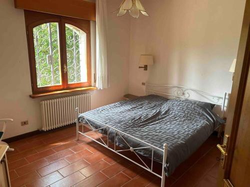 a bedroom with a bed in a room with a window at Villa Casa Camelia in Traumlage in San Bartolomeo