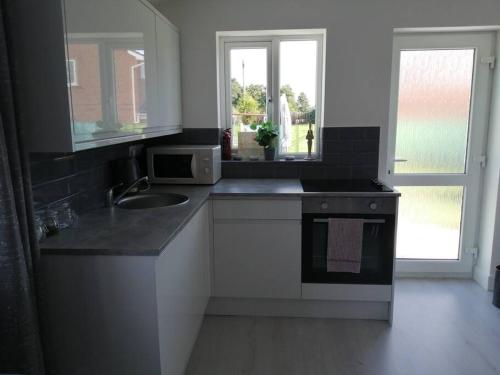 a kitchen with a sink and a stove at Self contained annexe in Kidderminster