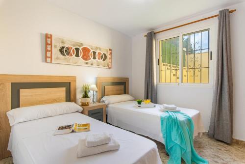 1 dormitorio con 2 camas y ventana en Villa Enzo - PlusHolidays, en Moraira