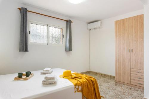 a white bathroom with a yellow towel on a tub at Villa Enzo - PlusHolidays in Moraira
