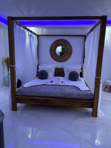 Bett in einem Zimmer mit Spiegel in der Unterkunft Chambres des délices in Villetelle