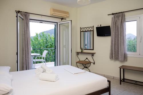 a bedroom with a bed and a balcony at Konstantinos Hotel & Apartments 2 in Nydri