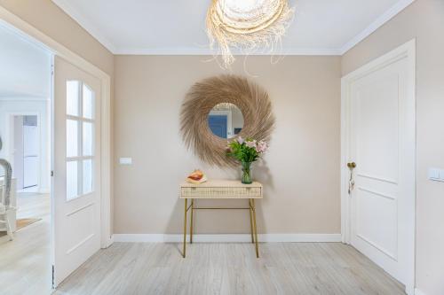 corridoio con specchio e tavolo con fiori di Apartamento excelente ubicación cerca de la playa a Marbella