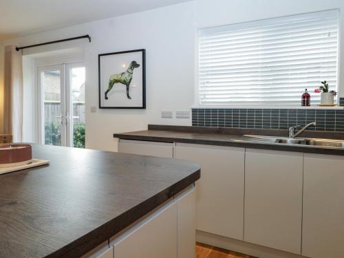 a kitchen with a counter with a horse on the wall at 1 Matrons Cottages in Littlehampton