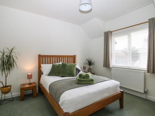 a bedroom with a bed with a green towel on it at 1 Matrons Cottages in Littlehampton
