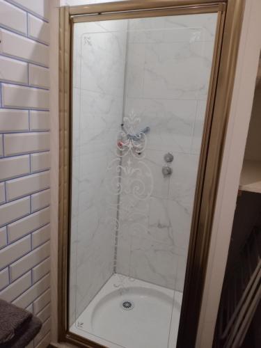 La salle de bains est pourvue d'une douche avec une porte en verre. dans l'établissement Chambre studio, à Calais
