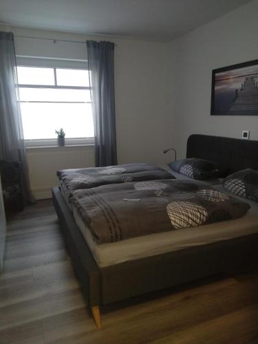 a bedroom with a large bed with a window at Mucki´s Ferienwohnung in Bad Zwischenahn