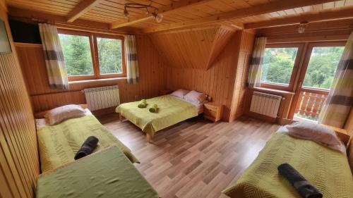 1 Schlafzimmer mit 2 Betten in einem Zimmer mit Fenstern in der Unterkunft Pod Gruszą in Dzianisz