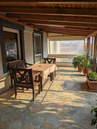 a patio with a wooden table and chairs on a porch at Lemon Tree in Agios Vlasios