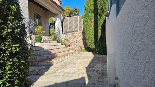 einen Steingang neben einem Haus mit Treppen in der Unterkunft Villa Farniente in Sète
