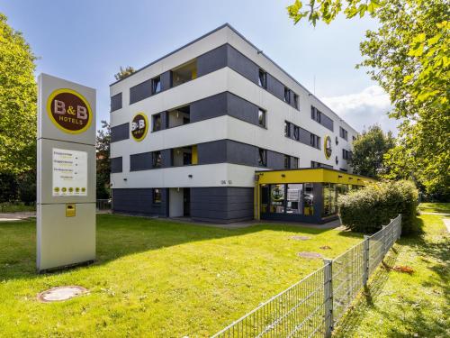 un bâtiment avec un panneau devant lui dans l'établissement B&B HOTEL Dortmund-Messe, à Dortmund