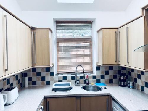 a kitchen with a sink and a window at Comfy House Near The City Centre in Nottingham