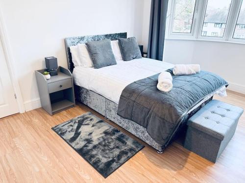 um quarto com uma cama grande e uma mesa de cabeceira em Comfy House Near The City Centre em Nottingham