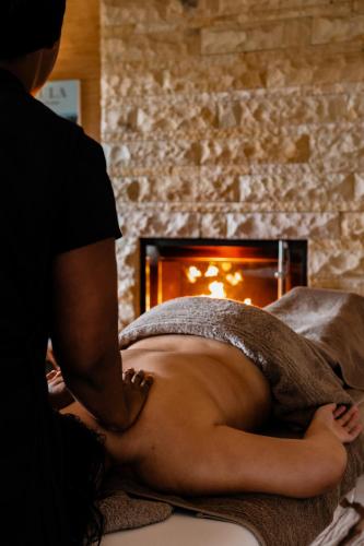 a woman laying on a bed getting a massage at Pezula Nature Retreat in Knysna