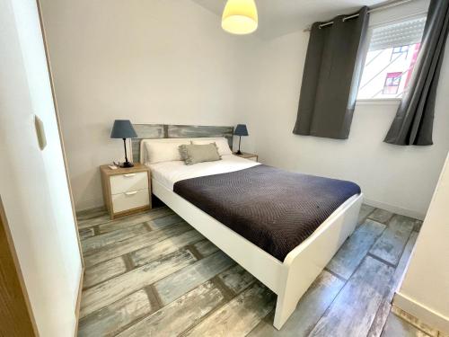 um quarto com uma cama e piso em madeira em AZ El Balcón de Aguadores - parking gratuito em Saragoça