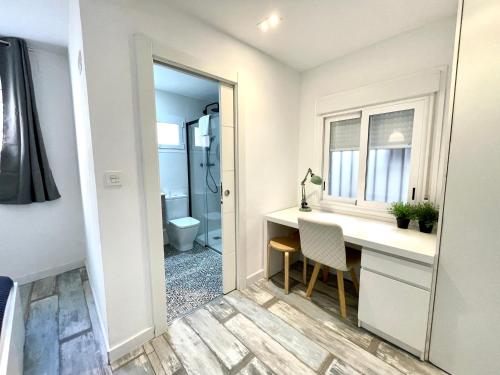 een badkamer met een bureau, een wastafel en een toilet bij AZ El Balcón de Aguadores - parking gratuito in Zaragoza
