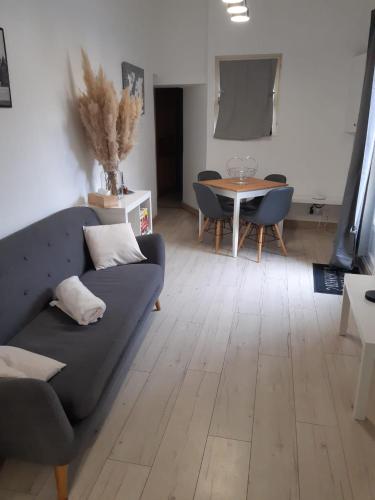 a living room with a couch and a table at Charmante maison dans le Gers, proche lac et centre-ville in LʼIsle-Jourdain
