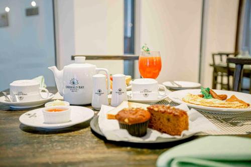 een tafel vol met borden met eten en een cupcake bij Emerald Bay Resort Mirissa in Mirissa