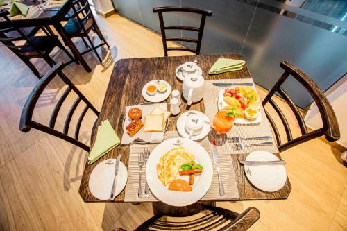 een houten tafel met ontbijtproducten erop bij Emerald Bay Resort Mirissa in Mirissa