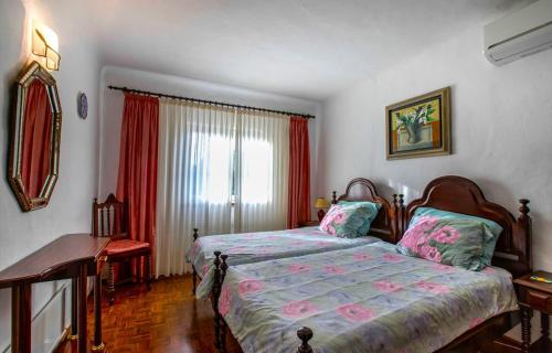 een slaapkamer met een bed en een raam bij Casa Rosfra in Carvoeiro