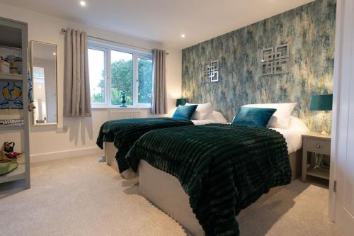 a bedroom with two beds with green blankets at Luxury Living Away From Home in Earlswood