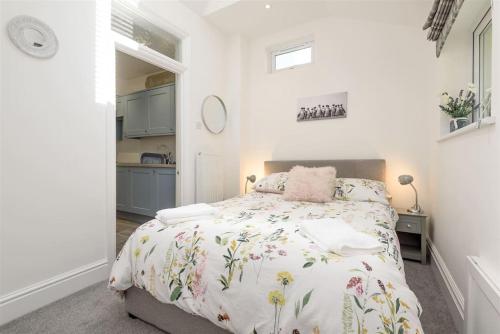 a bedroom with a bed and a kitchen at Rame in Looe