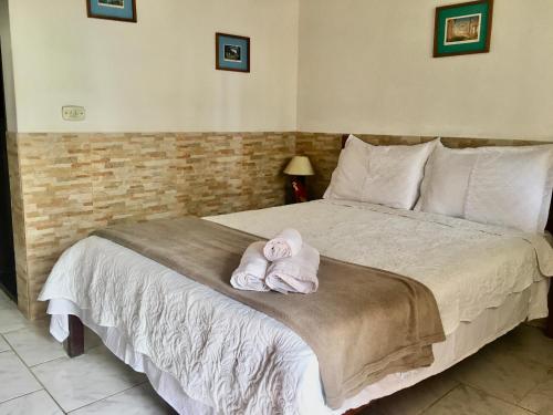 een slaapkamer met een bed met handdoeken erop bij Chácara kiwi in Paraty