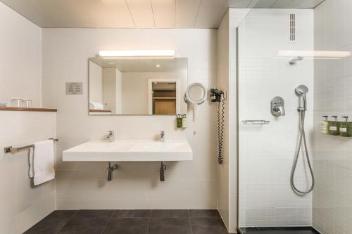 a white bathroom with a sink and a shower at ARTIEM Madrid in Madrid