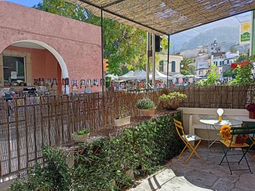 a patio with a table and chairs and a fence at Casa Es Mercat in Sóller