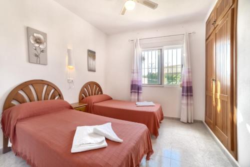a hotel room with two beds and a window at Villa Sasha - PlusHolidays in Calpe