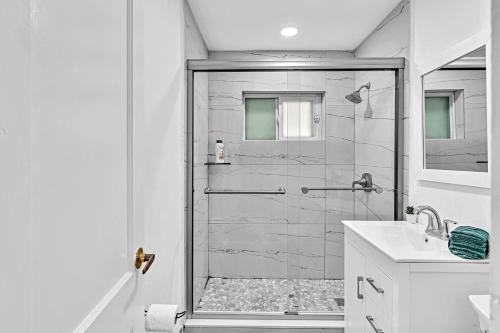a white bathroom with a shower and a sink at 3 Bedroom Villa In F Lauderdale Casino & Beach in Fort Lauderdale