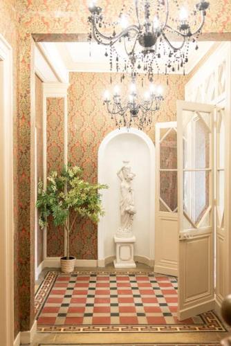 un couloir avec un lustre et une statue. dans l'établissement Immeuble L'Aristocrate - L'Epicurien- Bd Carnot, à Angers