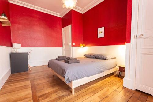 - une chambre avec des murs rouges et un lit dans l'établissement Immeuble L'Aristocrate - L'Epicurien- Bd Carnot, à Angers