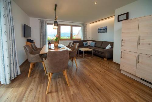 a living room with a table and chairs and a couch at Panoramablick Heimen in Hopferau