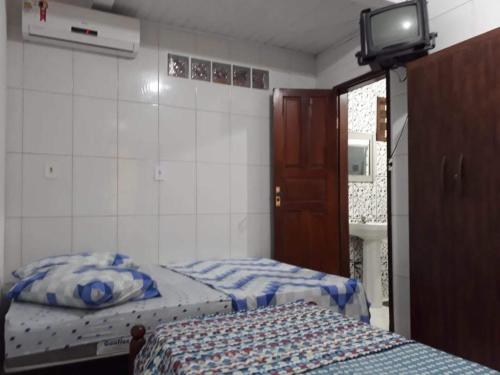 1 dormitorio con 2 camas y TV. en Residencial Lage, en Porto Seguro
