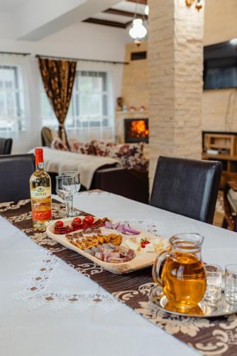 a table with a tray of food and a bottle of whisky at Pensiunea Ioana in Poeni