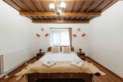 a bedroom with a bed with two towels on it at Pensiunea Ioana in Poeni