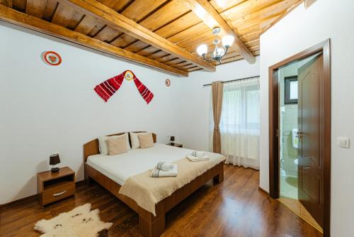 a bedroom with a bed in a room with wooden ceilings at Pensiunea Ioana in Poeni