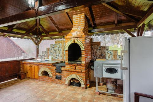 a kitchen with a brick oven in a room at Pensiunea Ioana in Poeni