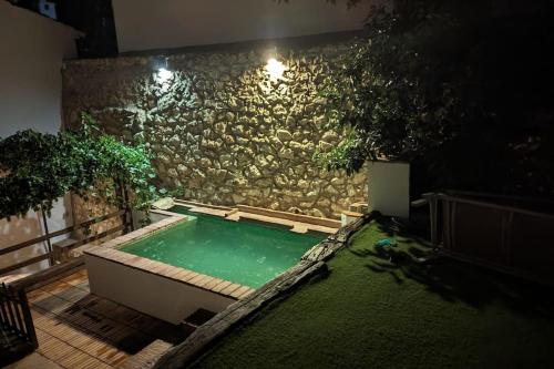 a swimming pool in front of a stone wall at Molino Viejo de Salar in Salar