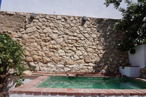 a stone wall next to a swimming pool at Molino Viejo de Salar in Salar
