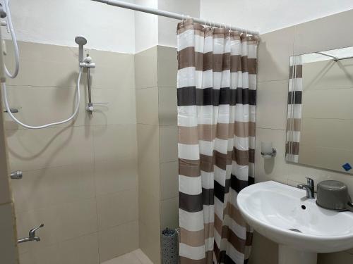 y baño con lavabo y ducha. en Uptown CDO Staycation en Cagayán de Oro