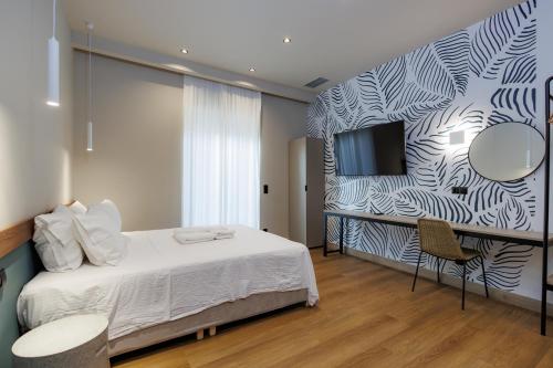 a bedroom with a bed and a tv on a wall at K2 Suites Kalamata in Kalamata