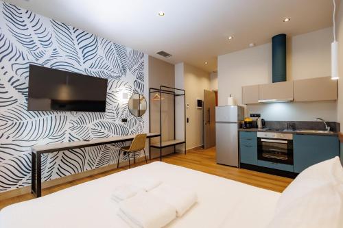 a bedroom with a large bed and a kitchen at K2 Suites Kalamata in Kalamata