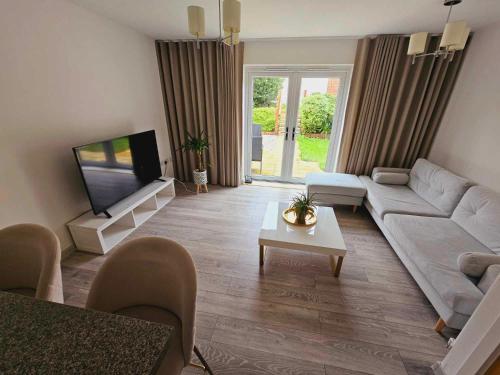 a living room with a couch and a tv at Entire 2 Bedroom House Modern Stylish Luxury in Plymouth