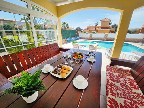 una mesa de madera con un plato de comida. en Villa Amarillo, en Caleta de Fuste