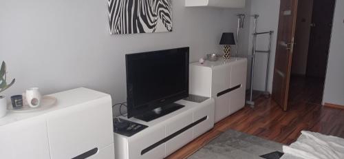 una sala de estar con TV en un armario blanco en Apartament 2 pokoje w centrum Opola en Opole