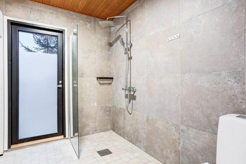 a shower with a glass door in a bathroom at Villa Karina - Beachfront with Jacuzzi in Porvoo